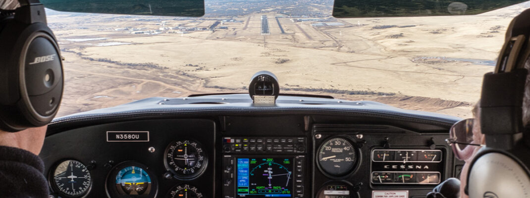 View from cockpit approaching desert runway for landing