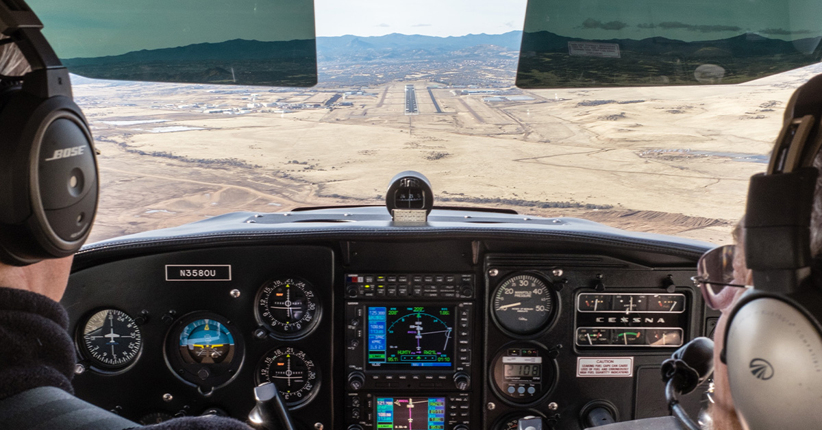 View from cockpit approaching desert runway for landing