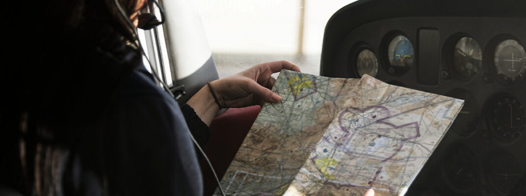 Female pilot looking at a sectional flight map