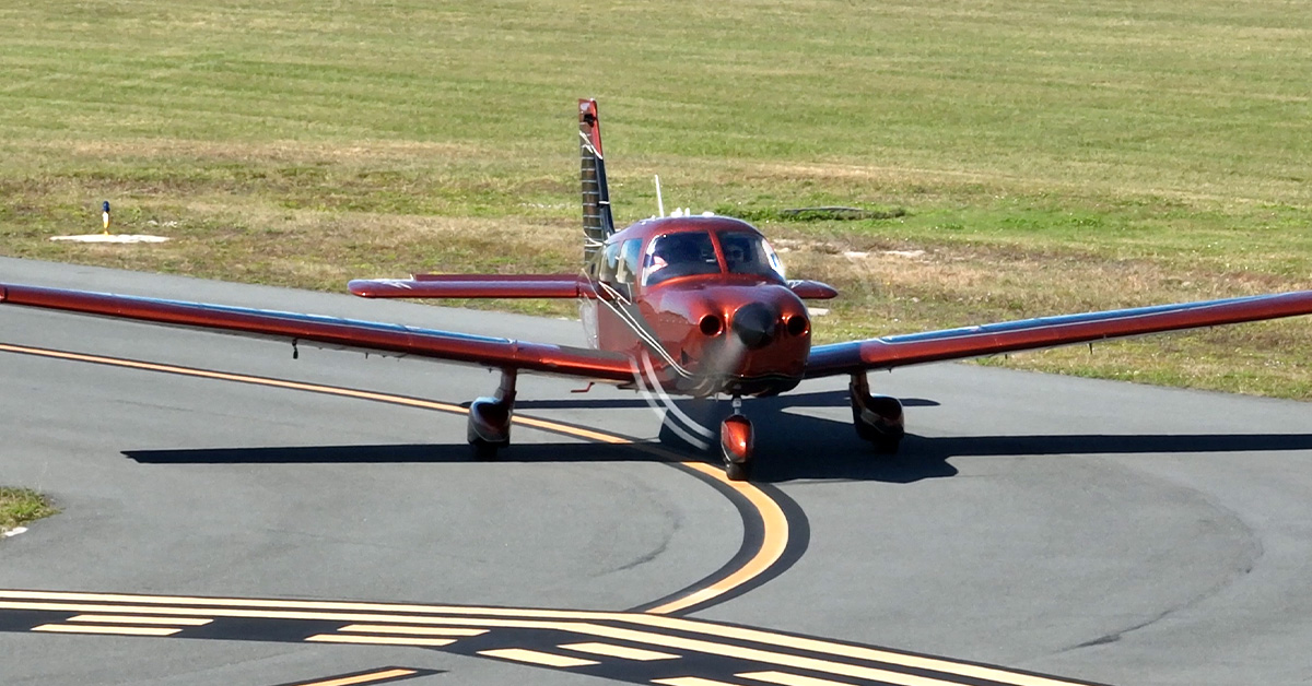 Piper Archer aircraft on rural airport taxiway during flight instruction