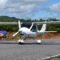 Light-sport fixed-wing aircraft performing landing during competition or flight training.