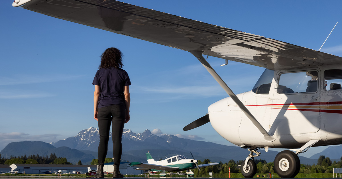 Photo of woman standing on airfield with small-engine planes