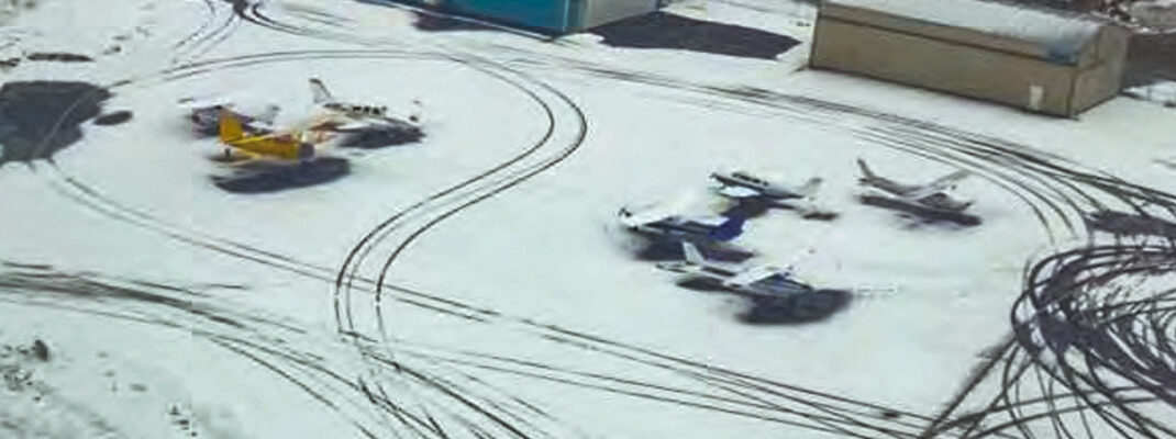 Winter weather at small airfield with tracks visible in snow