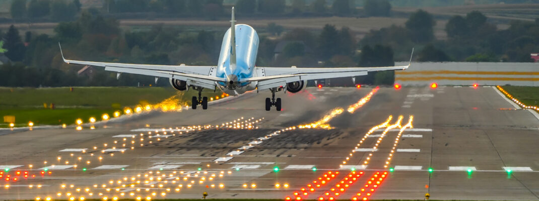 commercial airplane on a lighted runway during takeoff