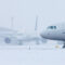 two planes and deicing on a snowy day