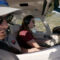 Profile view of a female student pilot and male CFI inside Piper Archer aircraft at mid-altitude and instructor is referencing book.