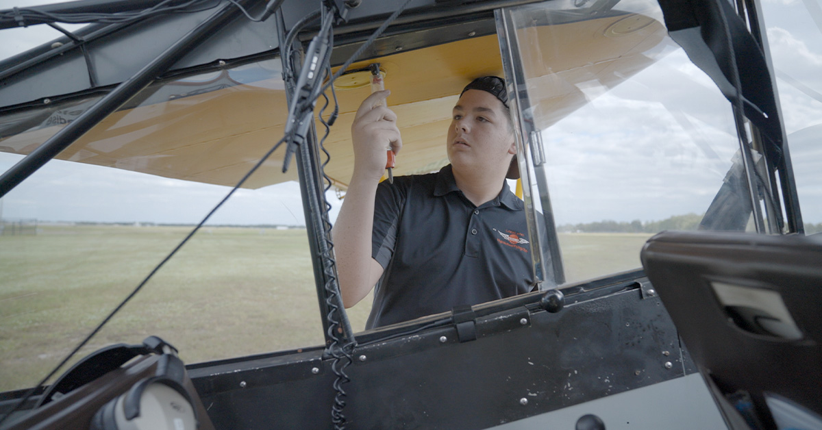 Young male student pilot performing check-ride preflight by testing mixture in pitot tube