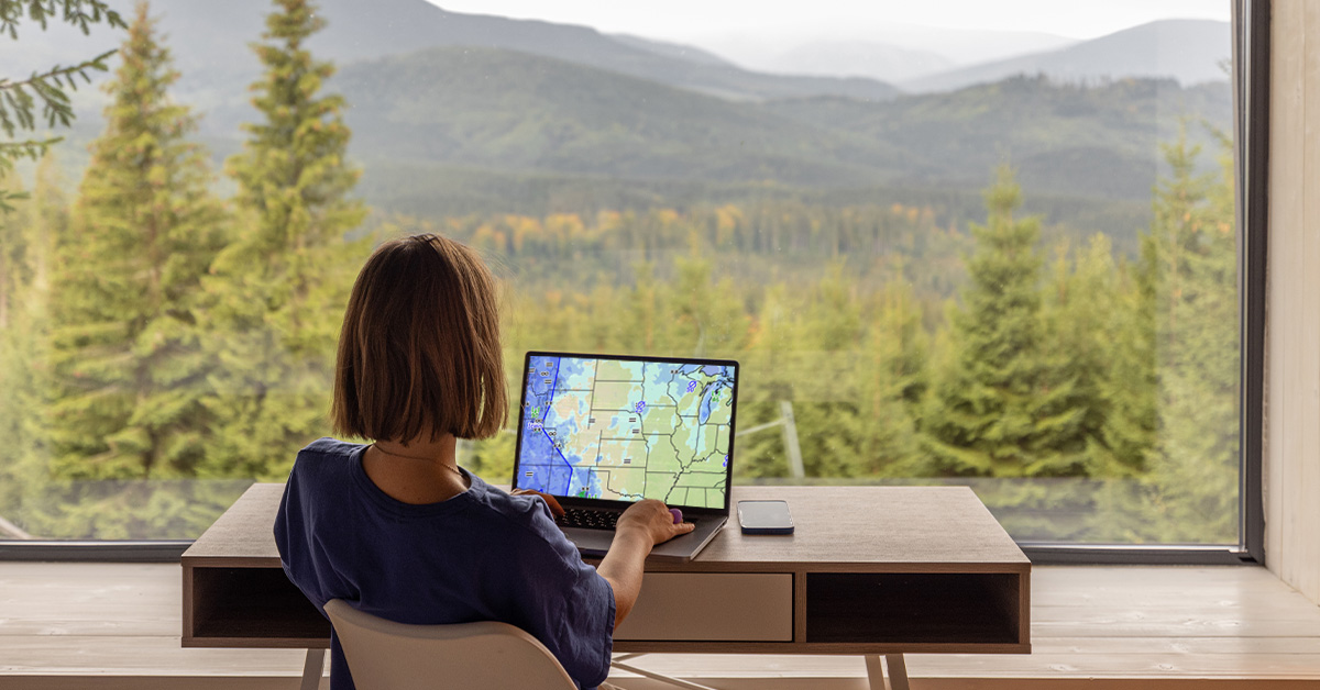 Woman viewing GFA output at home, mountain range visible outside window