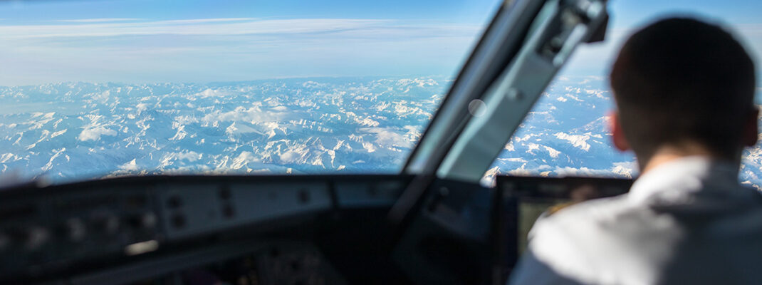 Pilot in a commercial airliner airplane flight cockpit during flight with great weather