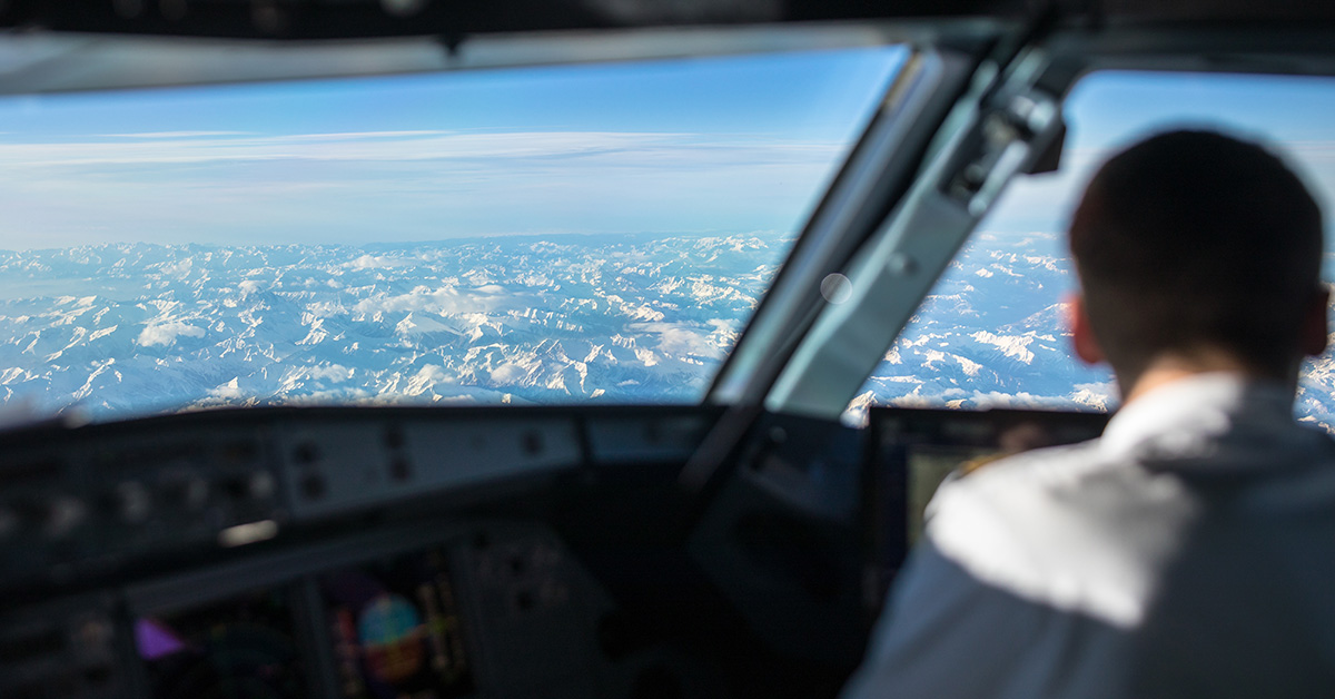 Pilot in a commercial airliner airplane flight cockpit during flight with great weather