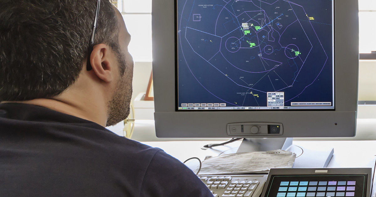 Airport communication procedures demonstrated by man identifying air traffic and rerouting