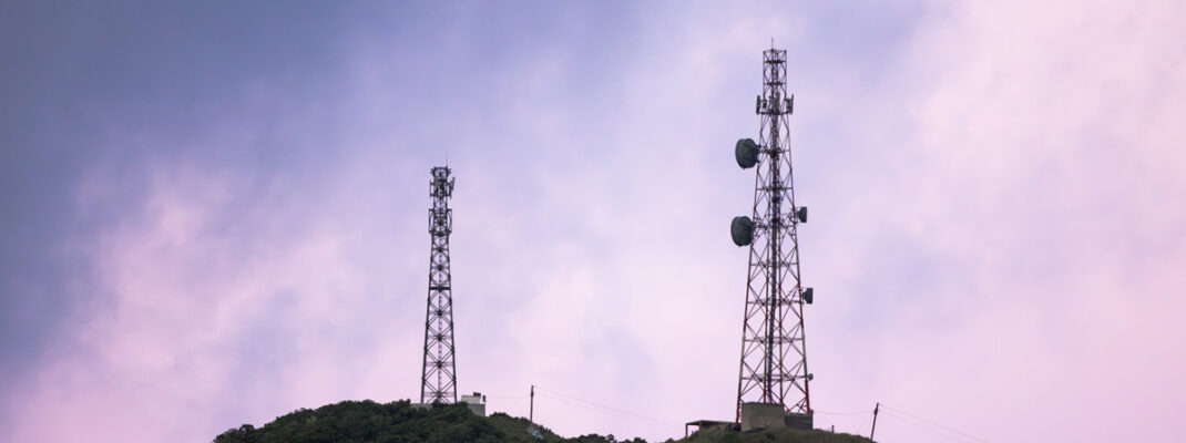 radio towers in front of pink sky