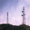 radio towers in front of pink sky