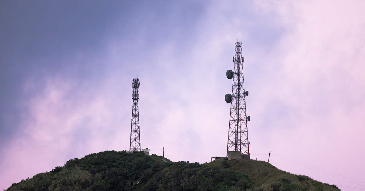 radio towers in front of pink sky