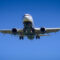 commercial airplane in flight wit deep blue sky background