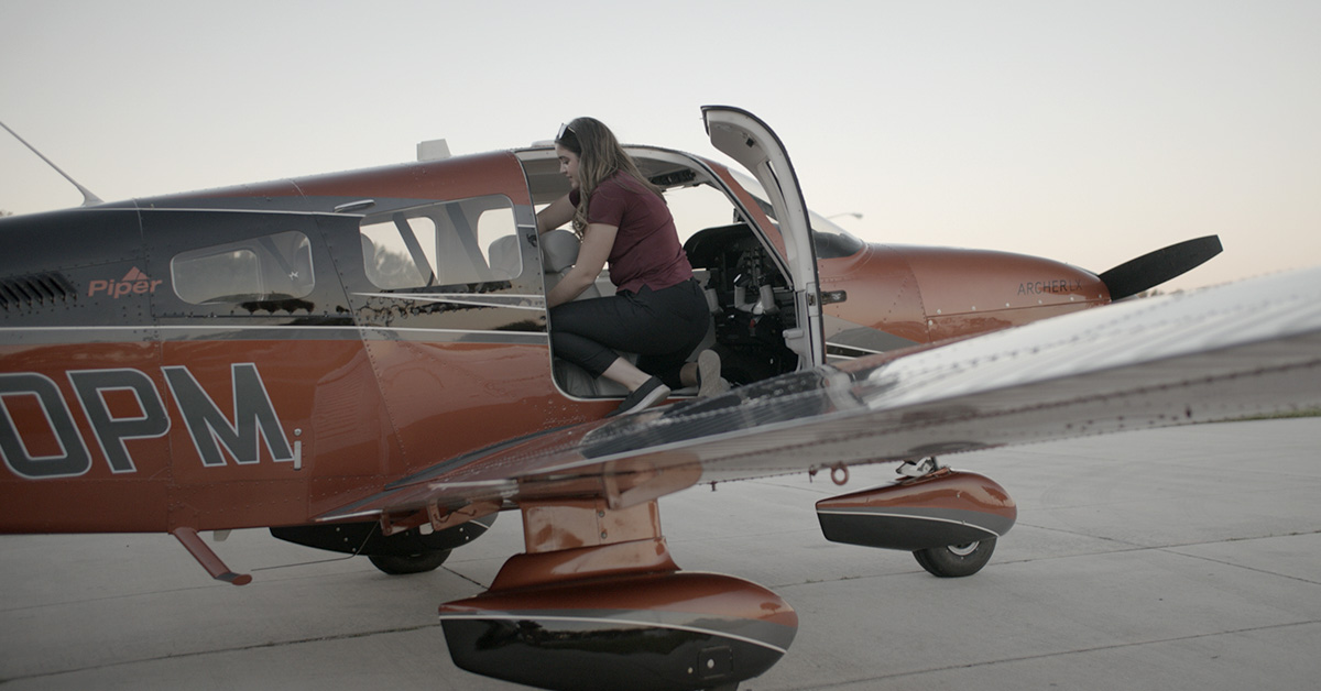 Female student pilot preparing for solo flight by performing checkride in Piper Archer airplane. Loading and checking back seats.
