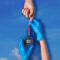 two hands completing a diabetes blood test atop sky background