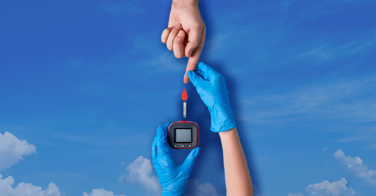 two hands completing a diabetes blood test atop sky background
