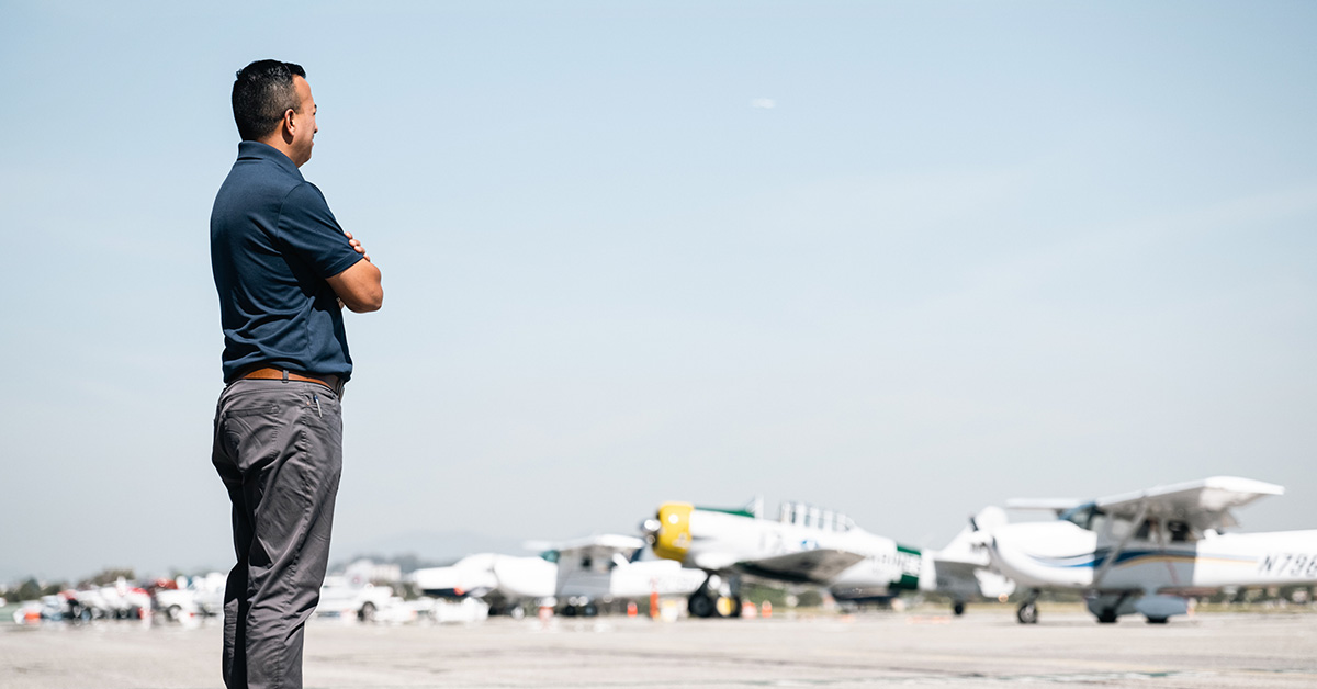 man looking at lineup of small airplanes and considering being a flight instructor