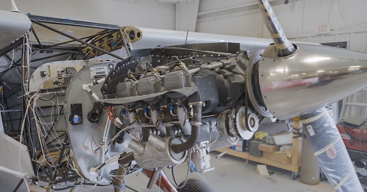 Small aircraft engine exposed in maintenance hanger to display cooling and other components