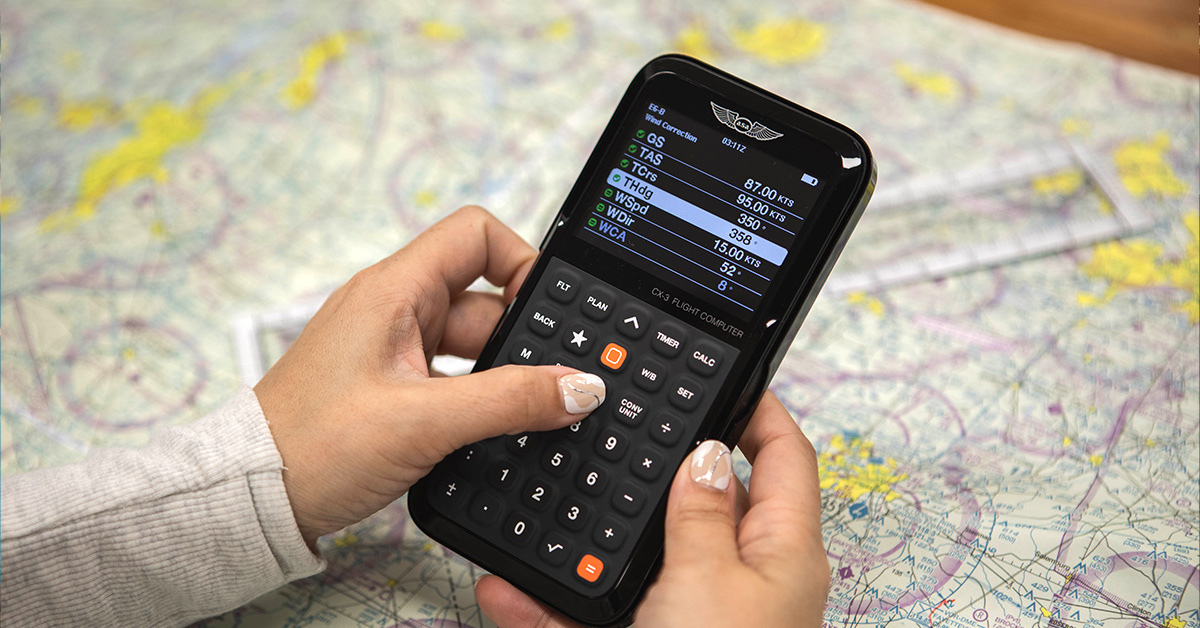 CX-3 flight computer calculating wind correction atop sectional map