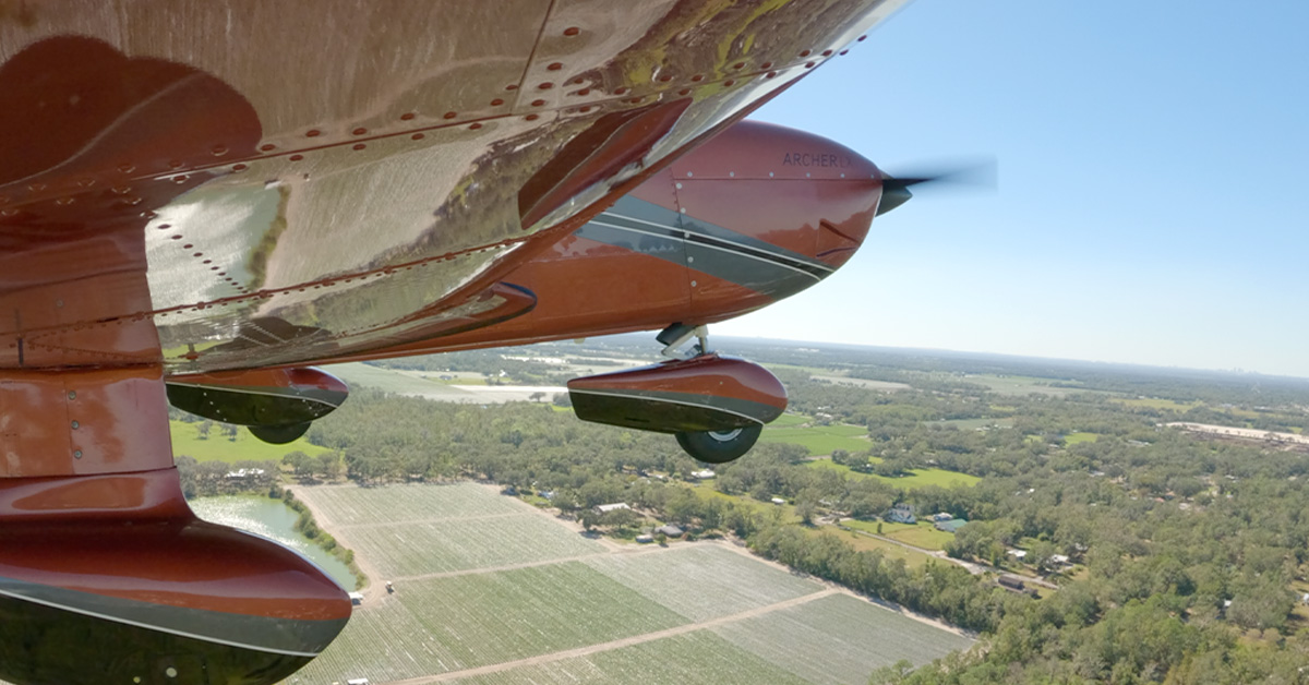 Piper Archer aircraft with field seen below