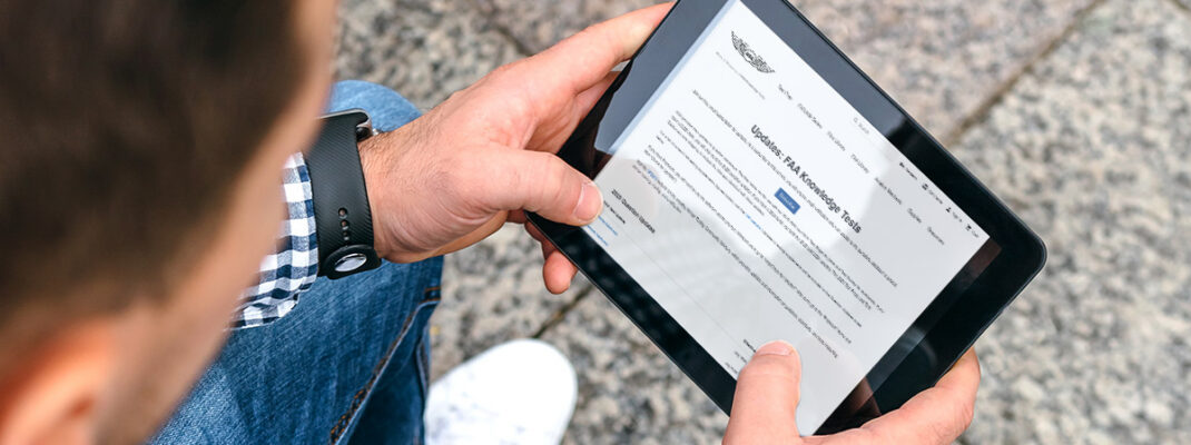 Man holding ipad with ASA's website and FAA test update listings
