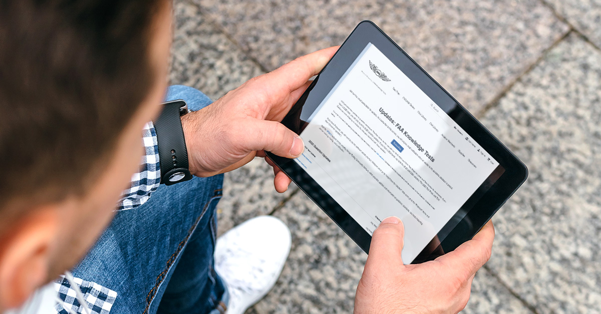 Man holding ipad with ASA's website and FAA test update listings
