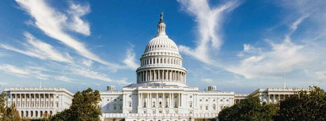 US capitol building from a distance with clouds in the background.