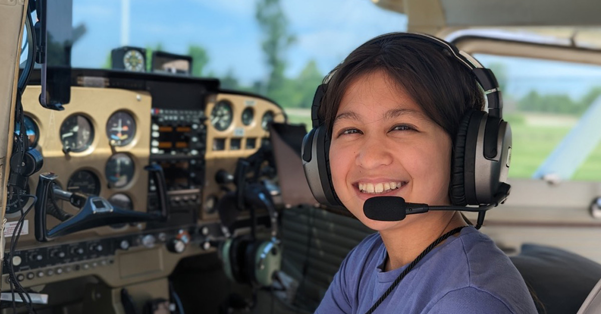 young student pilot wearing a headset in an airplane