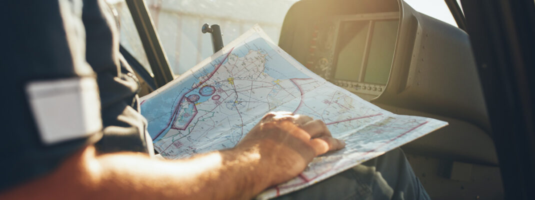 Helicopter pilot studying the flight route map