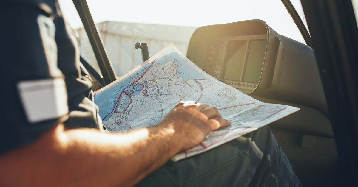 Helicopter pilot studying the flight route map