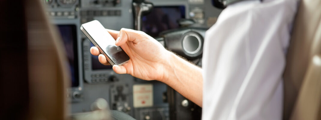 pilot checking cell phone for clearance