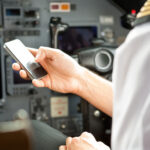 pilot checking cell phone for clearance