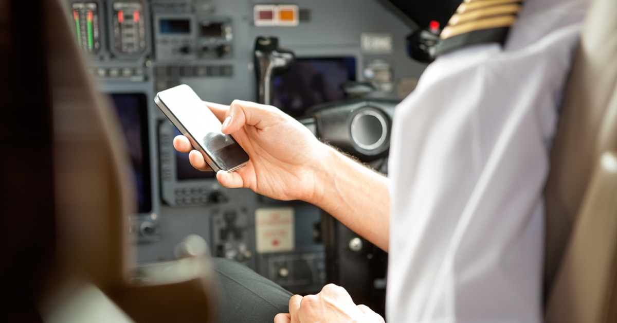 pilot checking cell phone for clearance